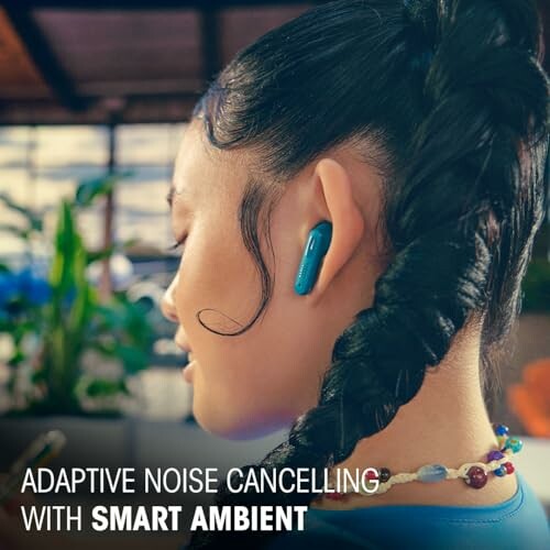 Person wearing adaptive noise cancelling earbuds with smart ambient feature.