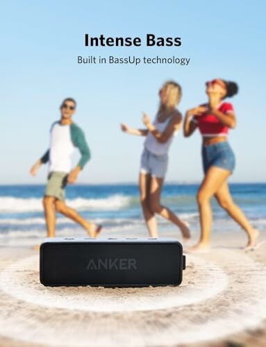 Anker speaker on beach with people dancing in background