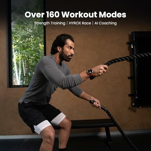 Man exercising with battle ropes in gym