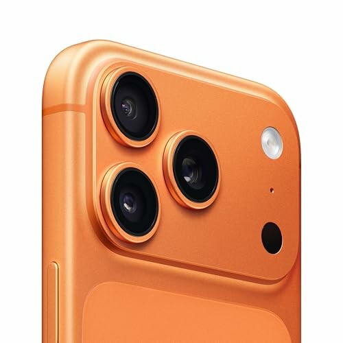 Close-up of an orange smartphone with triple camera setup.