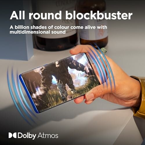 Person holding smartphone with game and Dolby Atmos effects.